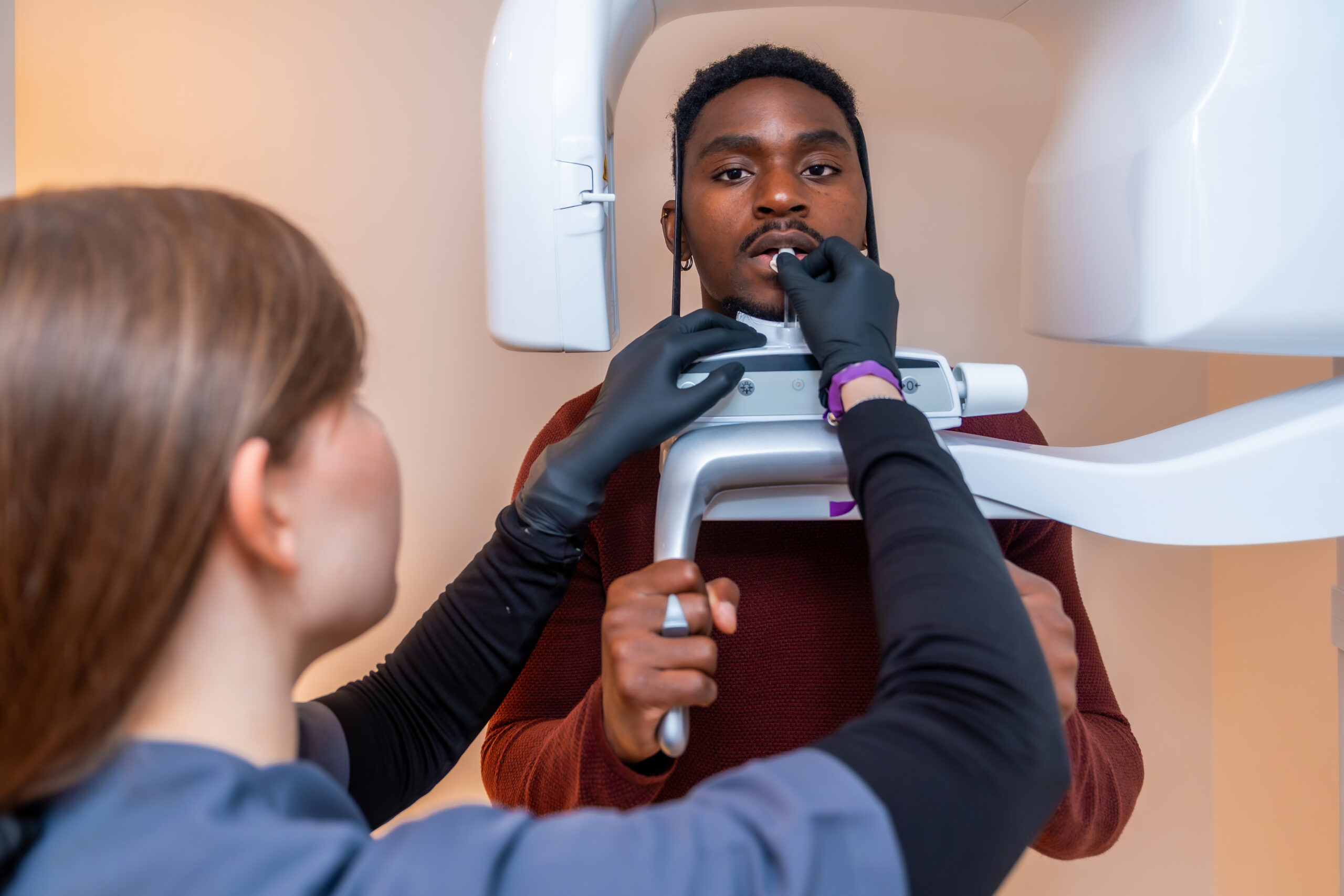 Dental professional preparing a patient for an x ray scan, ensuring precise positioning for a comprehensive dental examination